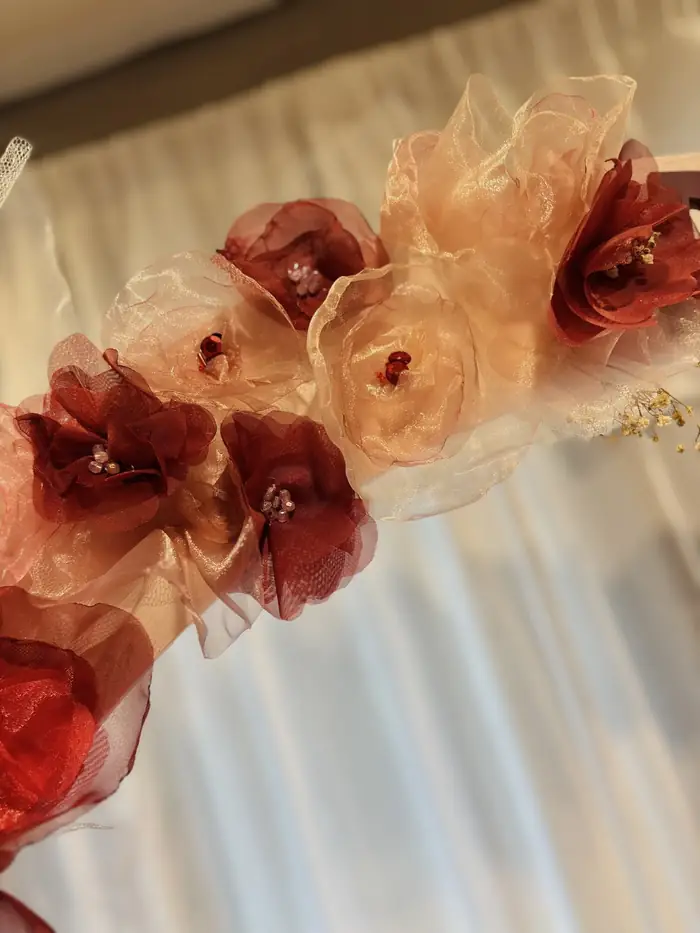 Detalle de flores artesanales rojas y rosas de un cartel