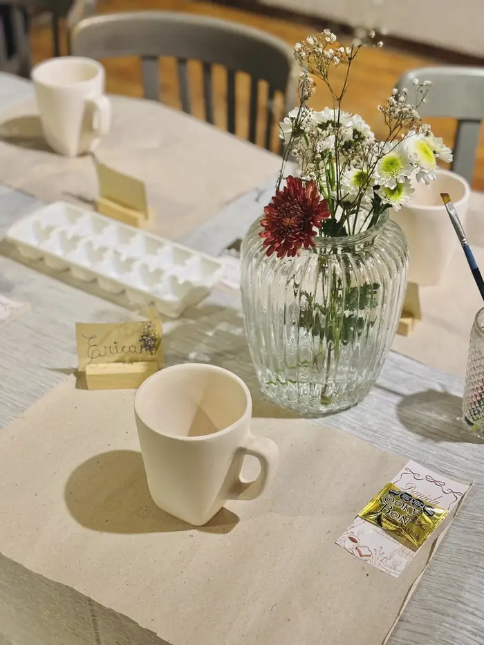 Mesa de evento ambientada con piezas de cerámica y flores naturales