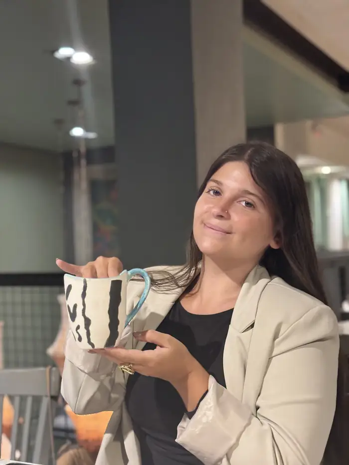 Clienta mostrando su pieza terminada en el taller