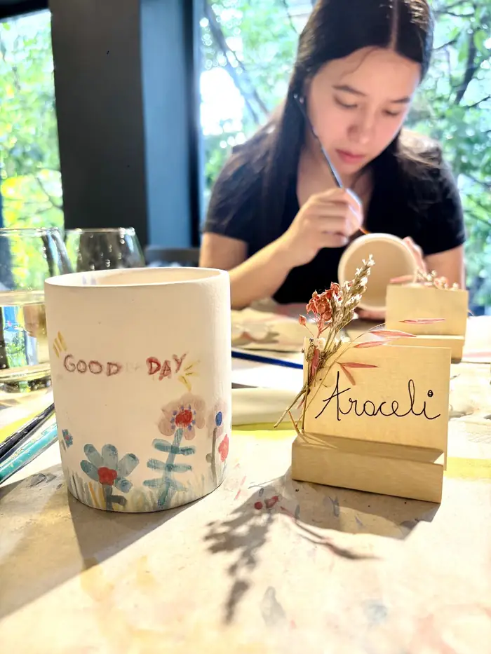 Participante pintando su taza de cerámica durante el taller